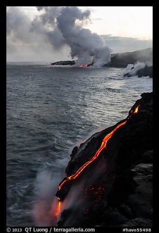 Bright molten lava flows into the Pacific Ocean, plume in background. Hawaii Volcanoes National Park (color)