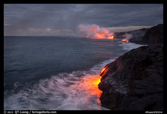 Streams of hot lava flow into the Pacific Ocean at the shore of erupting Kilauea volcano. Hawaii Volcanoes National Park, Hawaii, USA.