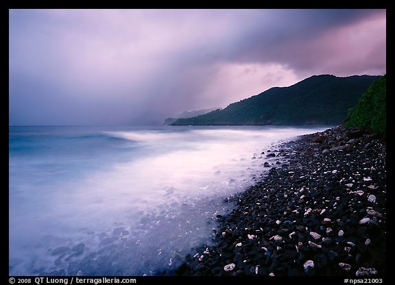 Coastline with dark rocks, light water and storm sky at sunrise, Vatia bay, Tutuila Island. National Park of American Samoa