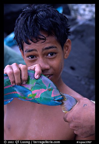 Samoan boy with freshly catched tropical fish, Tau Island. National Park of American Samoa