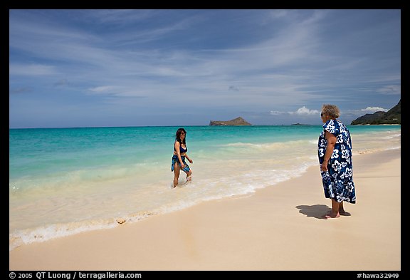 Two women, the older in hawaiian dress, on Waimanalo Beach. Oahu island, Hawaii, USA