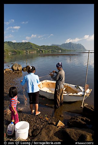 Fishing family working around small baot, Kaneohe Bay, morning. Oahu island, Hawaii, USA