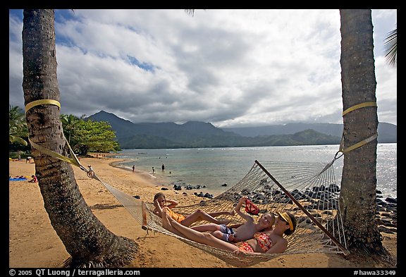 Family on Hammock with Hanalei Bay in the background. Kauai island, Hawaii, USA