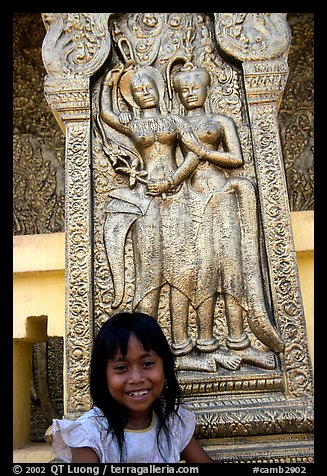 Girl and sculpture at Wat Phnom. Phnom Penh, Cambodia (color)