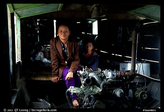 Engine and pilot at the rear of a slow passenger boat. Mekong river, Laos (color)