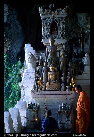 Novice Buddhist monk and vistor in Pak Ou cave. Laos (color)