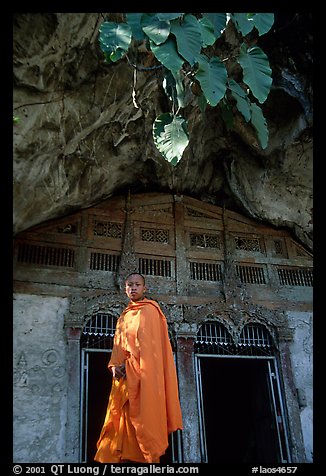 Novice Buddhist monk at entrance of lower Pak Ou cave. Laos (color)