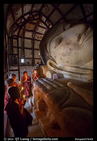Novices praying in front of Shinbinthalyaung reclining Budddha head. Bagan, Myanmar (color)