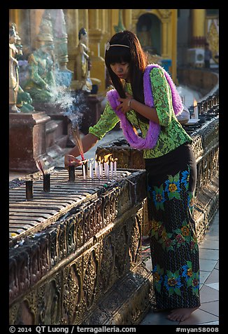 Woman lighting candles, Shwedagon Pagoda. Yangon, Myanmar (color)