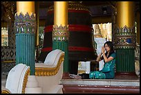 Woman praying next to bell, Shwedagon Pagoda. Yangon, Myanmar