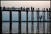 U Bein Bridge with monks and visitors strolling at dusk. Amarapura, Myanmar ( color)