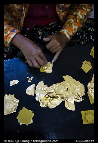 Close-up of hands separating gold leaves. Mandalay, Myanmar (color)