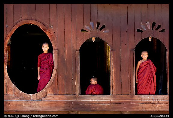 Buddhist monks looking through windows of Shweyanpyay Monastery, Nyaung Shwe. Inle Lake, Myanmar (color)