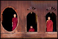 Buddhist monks looking through windows of Shweyanpyay Monastery, Nyaung Shwe. Inle Lake, Myanmar ( color)