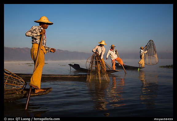Intha fishermen standing on stern of their boats to fish. Inle Lake, Myanmar (color)