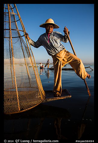 Intha fisherman prepares to release conical basket. Inle Lake, Myanmar (color)