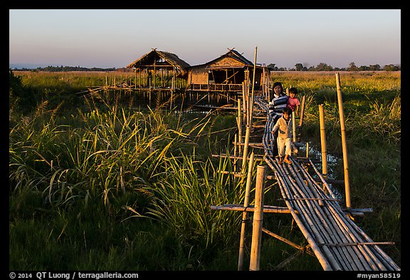 Family walking out of stilt house on precarious bridge. Inle Lake, Myanmar (color)