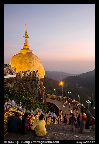 Pilgrims look at the Golden Rock from lower platform at sunset. Kyaiktiyo, Myanmar (color)
