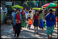 Women walk with platers of food on their heads. Kyaiktiyo, Myanmar ( color)