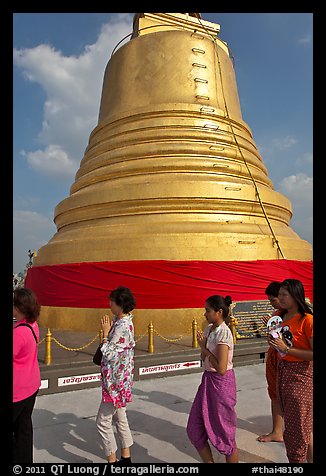 Worshippers circle around chedi. Bangkok, Thailand (color)