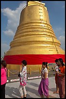 Worshippers circle around chedi. Bangkok, Thailand (color)