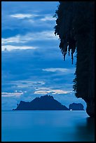Limestone crag with stalactite, distant islet, boat light, Railay. Krabi Province, Thailand ( color)