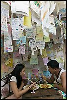 Couple eating Pad Thai below notes of praise left by customers, Ko Phi Phi. Krabi Province, Thailand (color)