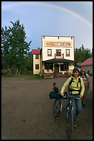 Women with bikes, hotel, and rainbow. McCarthy, Alaska, USA