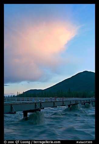 Footbridge with the Kennicott River swelled from the annual Hidden Lake flood. McCarthy, Alaska, USA