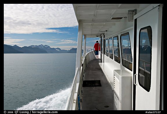 Passenger standing outside tour boat. Seward, Alaska, USA (color)