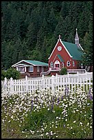 White flowers,  picket fence, red church, and forest. Seward, Alaska, USA