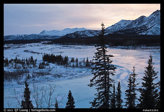 Winter landscape with frozen river at sunset. Alaska, USA