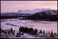 Frozen river and mountains at sunset. Alaska, USA