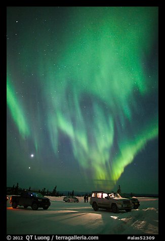 Northern Lights dance above snowy parking lot. Alaska, USA