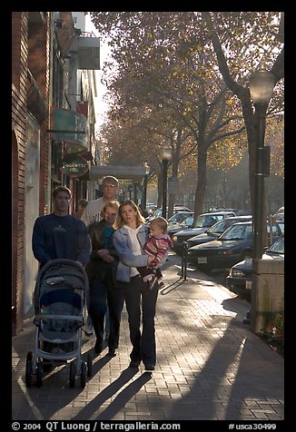 Family strolls on the sidewalk of University Avenue. Palo Alto,  California, USA