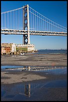 Bay Bridge reflected in water puddles. San Francisco, California, USA (color)