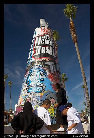 Young men decorating a cone on the beach. Venice, Los Angeles, California, USA (color)