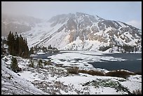 Partly frozen Ellery Lake and mountains with snow. California, USA