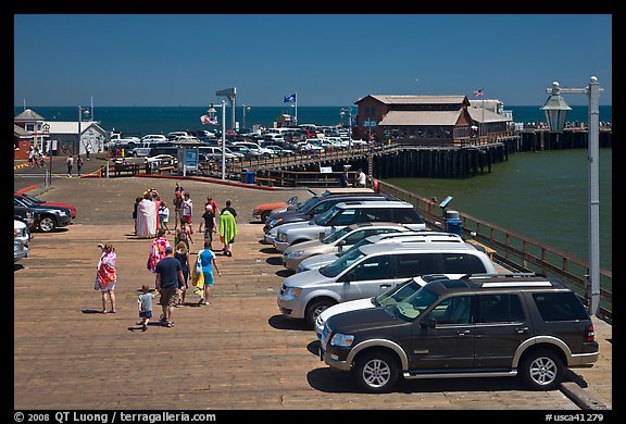 People drapped with colorful towels walking on wharf. Santa Barbara, California, USA