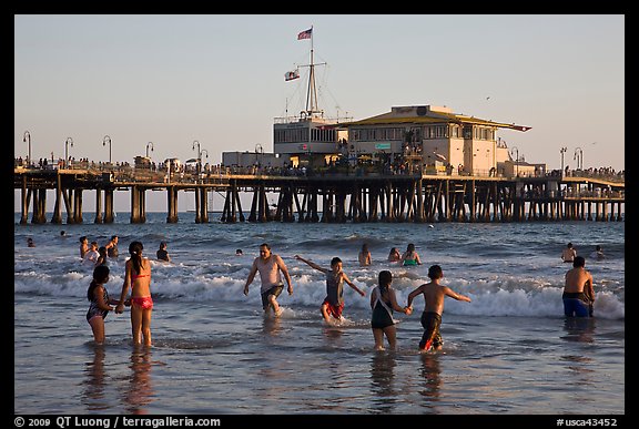 People bathing in ocean and Santa Monica Pier, late afternoon. Santa Monica, Los Angeles, California, USA