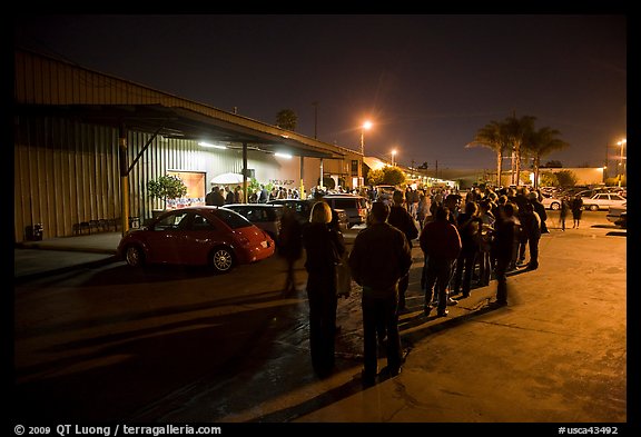 People lining up to enter a gallery at night, Bergamot Station. Santa Monica, Los Angeles, California, USA