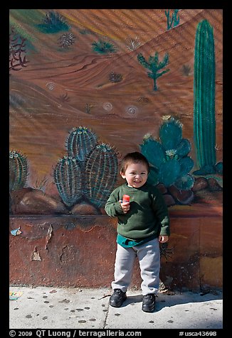 Boy and mural, Mission District. San Francisco, California, USA
