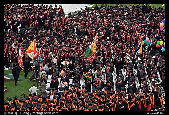 Academic flags exit amongst crow of graduates after commencement ceremony. Stanford University, California, USA