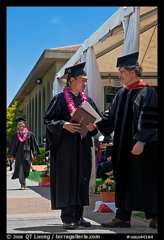 Graduate wearing lei presented with diploma. Stanford University, California, USA