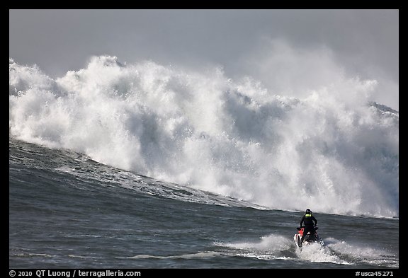 Jet ski dwarfed by huge breaking wave. Half Moon Bay, California, USA
