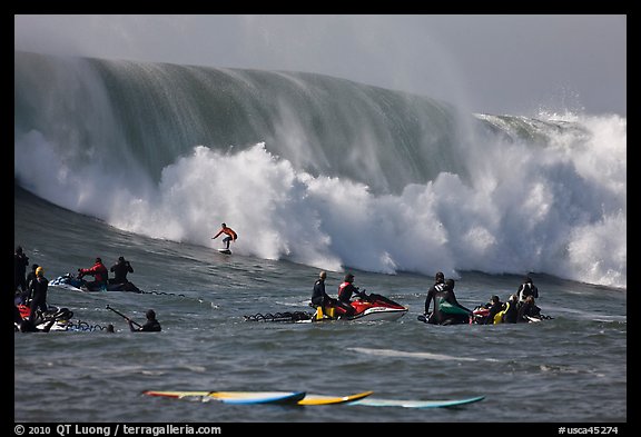 Waverunners and surfer in big wave. Half Moon Bay, California, USA