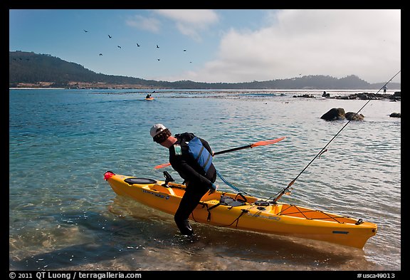 Man boards sea kayak, Carmel Bay. Carmel-by-the-Sea, California, USA (color)