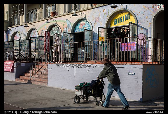 Man pushing cart in front of stores. Venice, Los Angeles, California, USA (color)