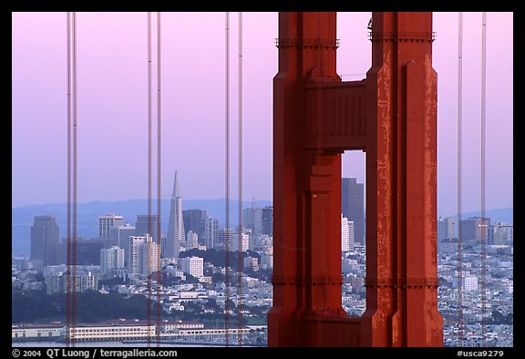 The city seen through the cables and pilars of the Golden Gate bridge, dusk. San Francisco, California, USA