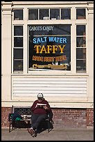 Man reading in front of Salt Water taffy store, Provincetown. Cape Cod, Massachussets, USA